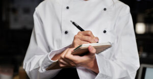 pagar menos imposto restaurante - chef anotando em caderno